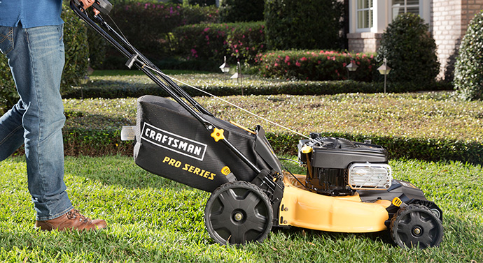 Man using a Craftsman Pro Series push mower to cut lawn